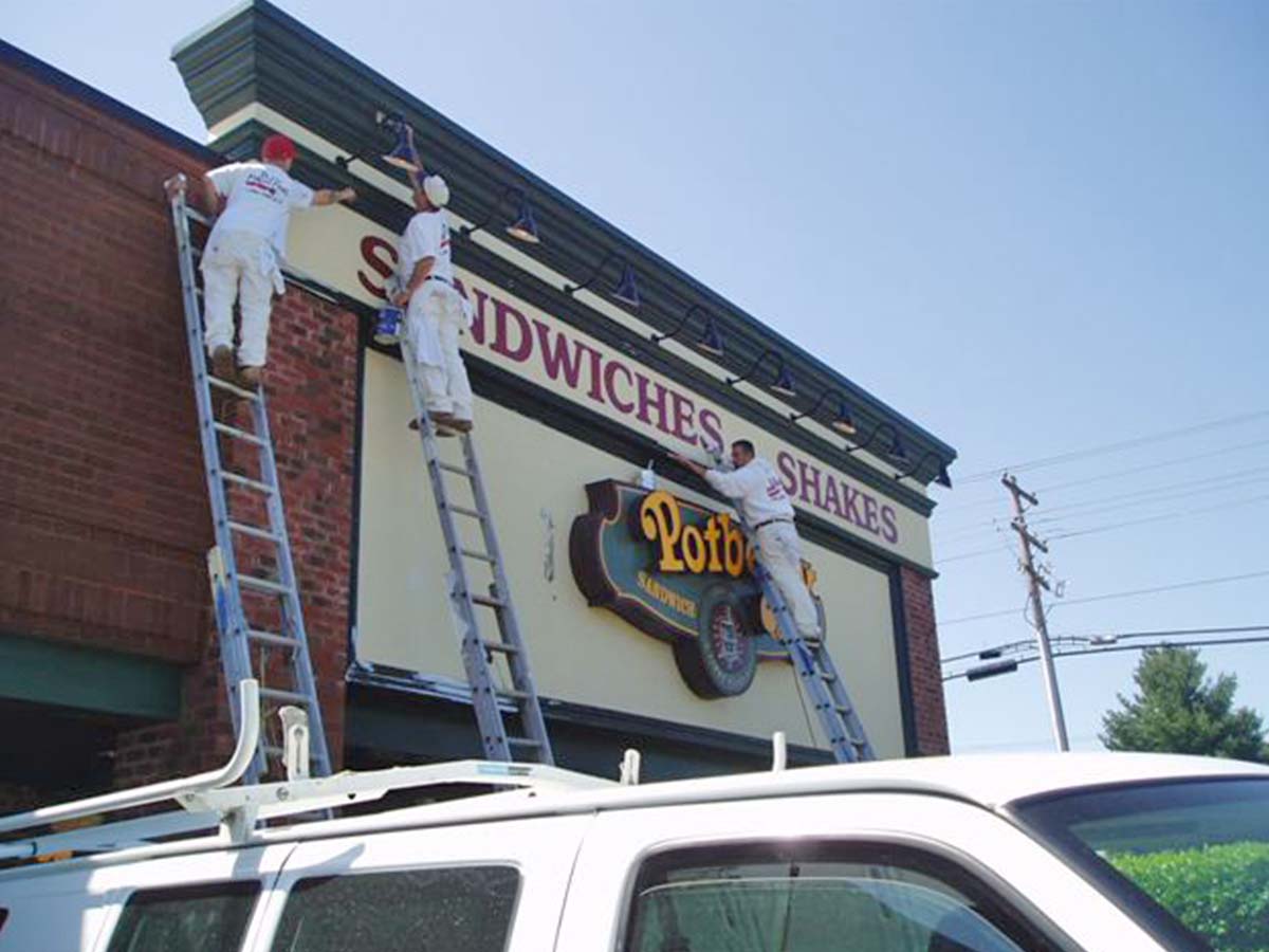 three men painting a business