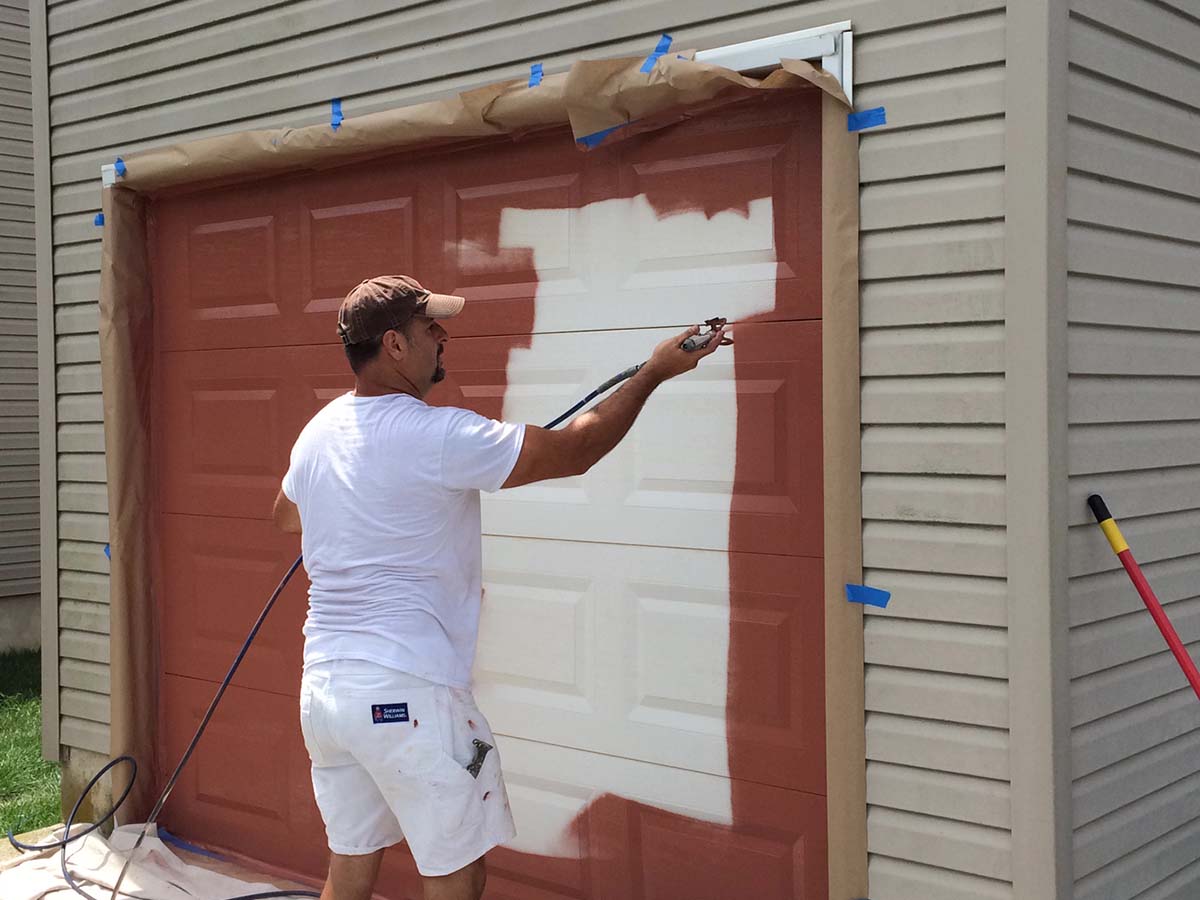 man painting garage door
