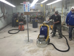 Starting proper garage floor coating with sanding and vacuuming.