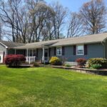 Freshly painted grey siding, white trim and black shutters on a residential home