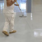 Man coating white floor