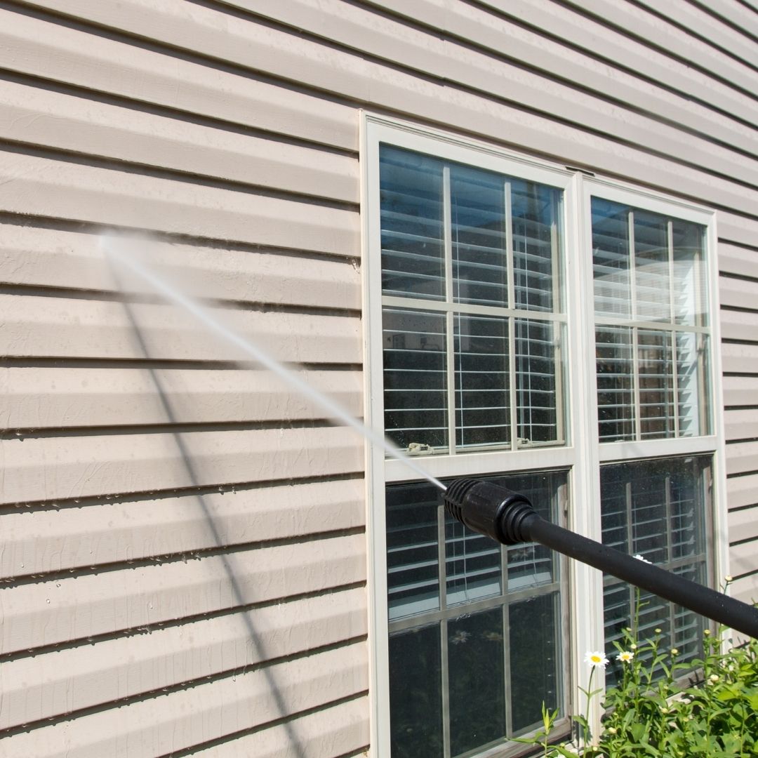 photo of someone power washing home exterior