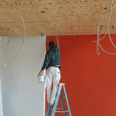 Commercial foyer entryway being painted orange I am man on a step ladder